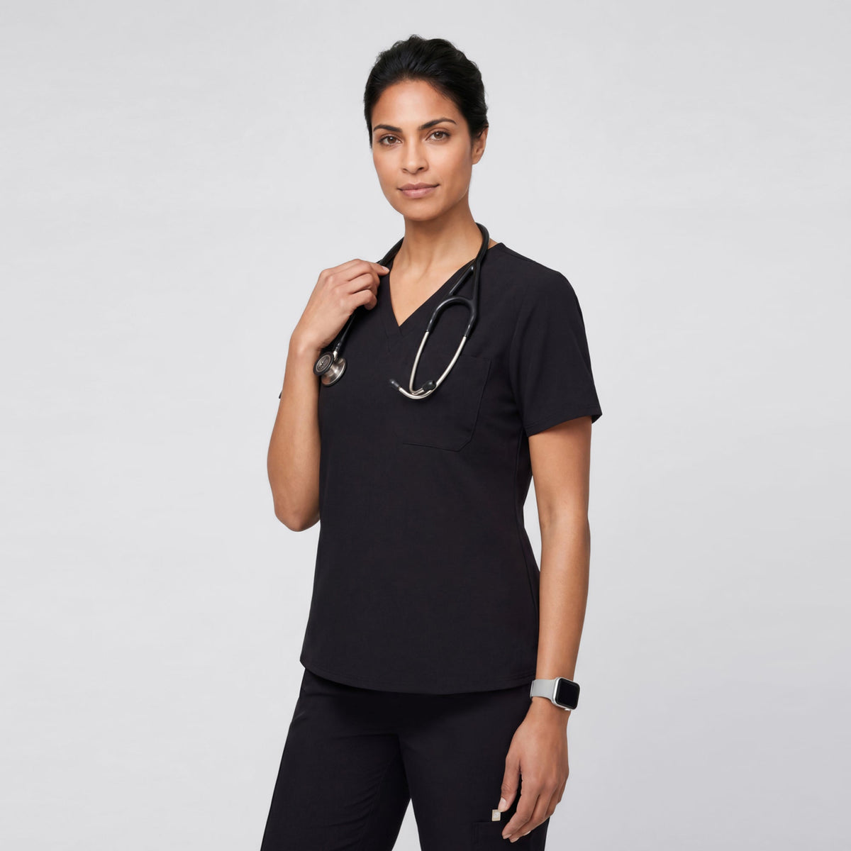 Eco Black 3 Pocket Scrub Top in a candid walking pose, captured mid-motion with a bright smile for a natural and energetic vibe.