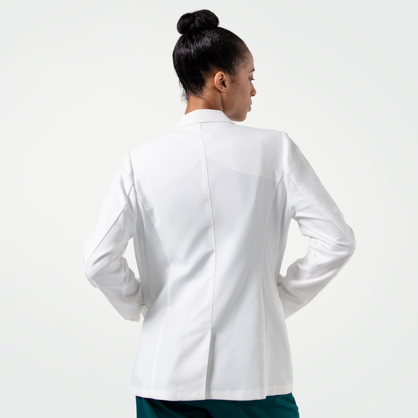 Upper body shot of the model turned around, wearing the Women's LCW-101 Lab Coat over pine green scrubs, looking slightly to the side