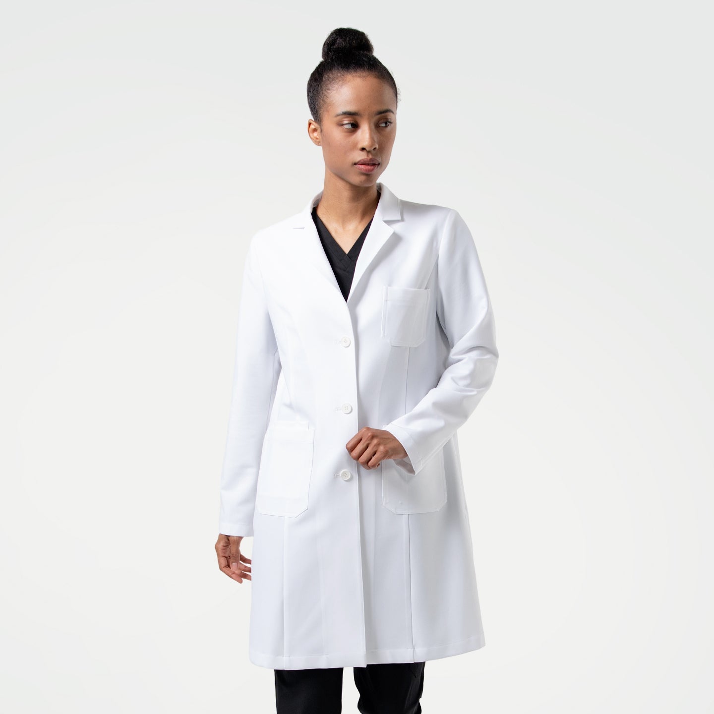 Woman wearing the Women's LCW-102 Lab Coat in White over medical scrubs, standing and looking to the side,White