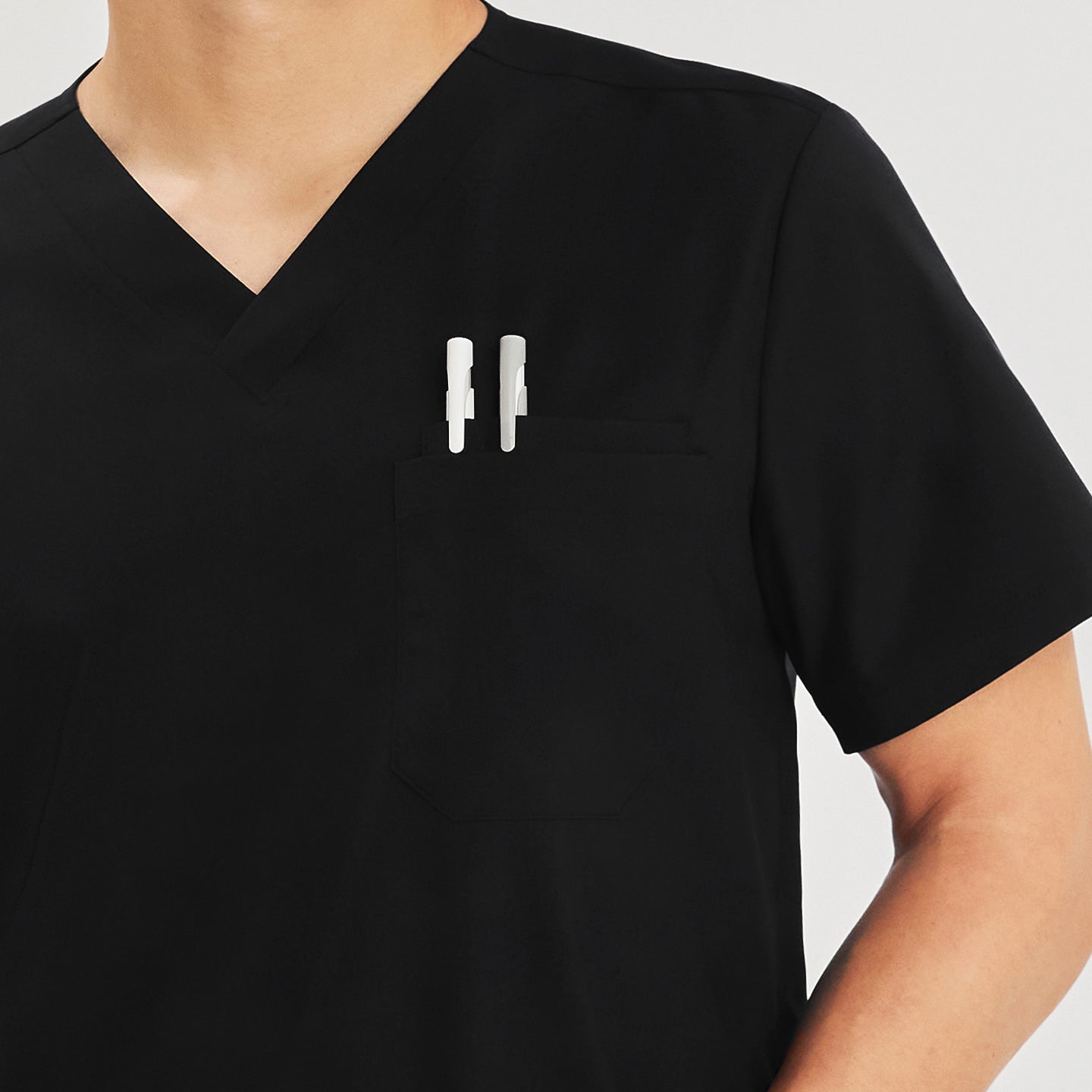 Close-up of a scrub top chest pocket with two pens tucked in,Eco Black