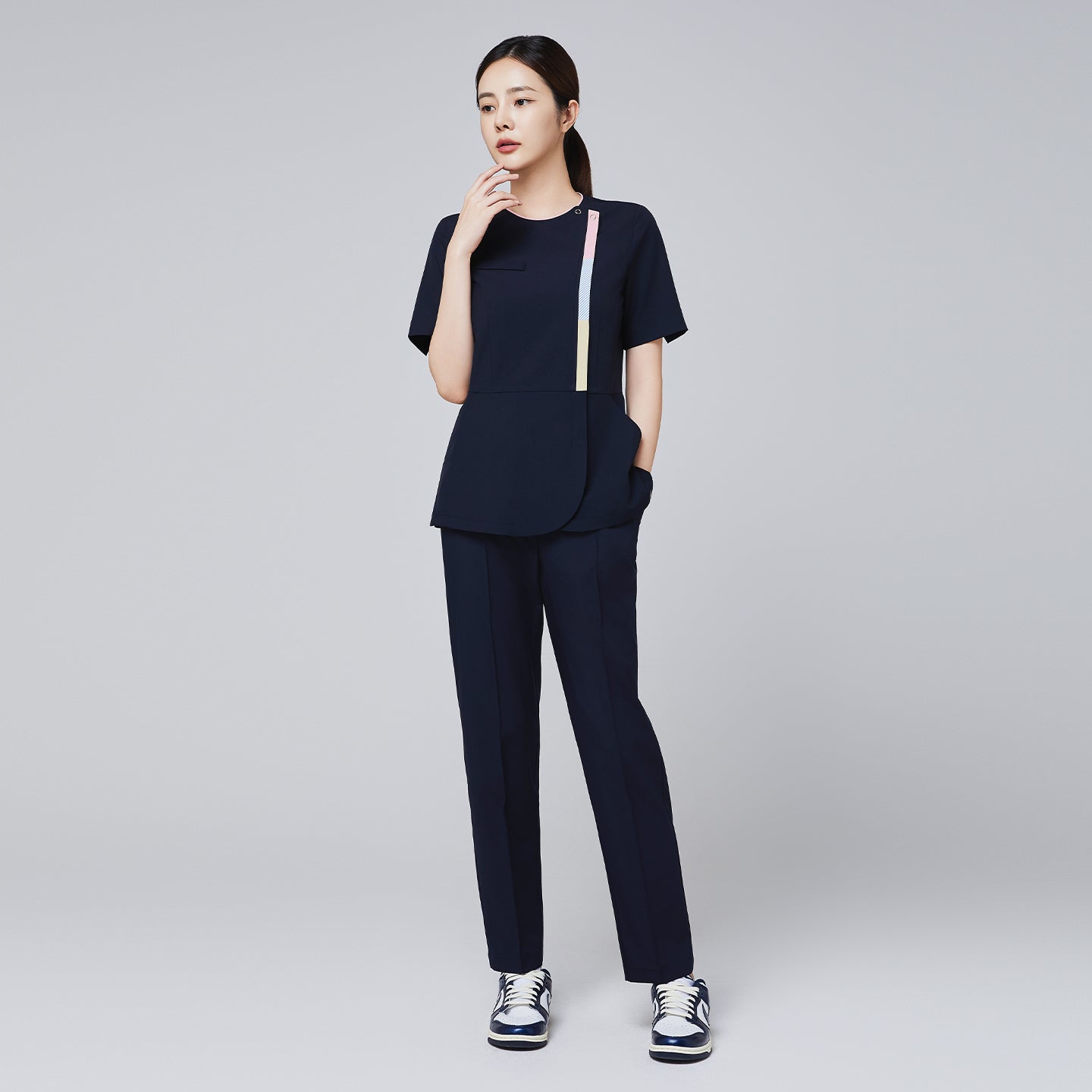 Eco navy scrub set with short-sleeve top featuring colorful stripe detail and matching banding pants, paired with navy and white sneakers,Eco Navy