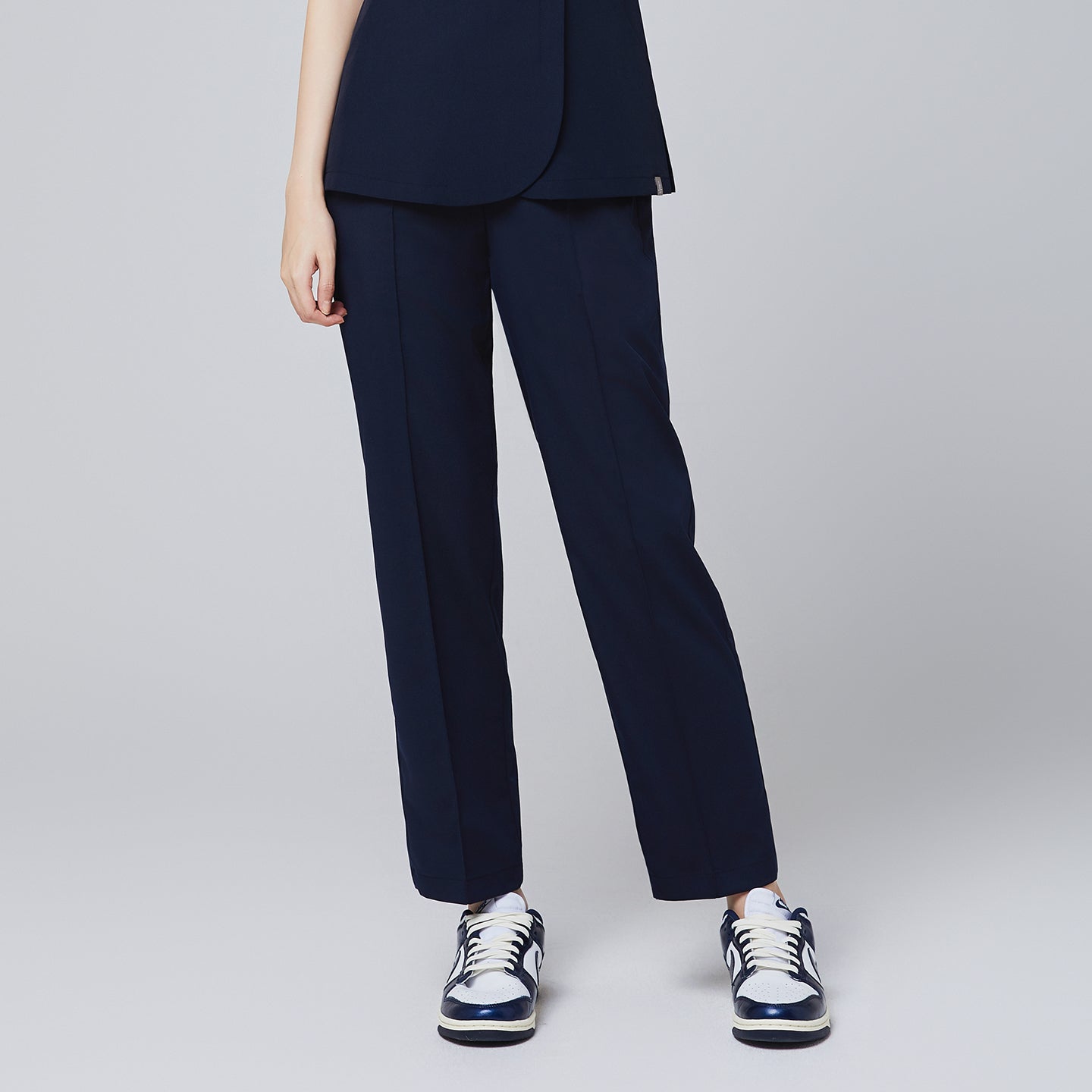 Close-up of eco navy banding scrub pants with a tailored fit, styled with navy and white sneakers for a professional look,Eco Navy