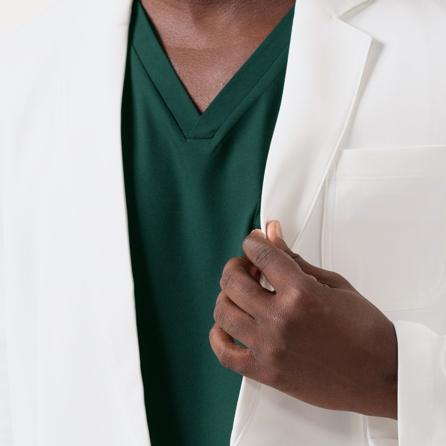 A close-up view of the LCM-201 lab coat highlights its convenient chest pocket, where an ID badge reel is smoothly clipped for quick access, showcasing the coat’s practical design and its clean, structured tailoring that supports everyday clinical use.