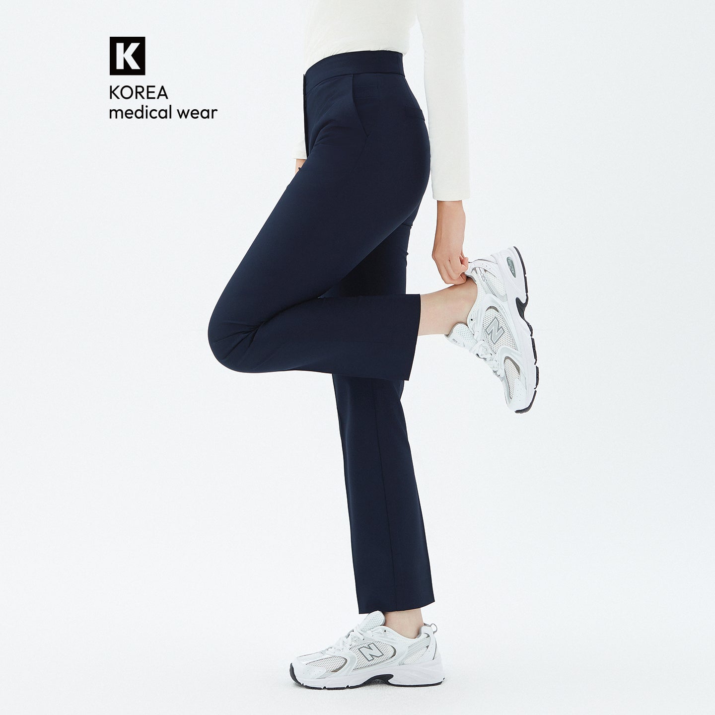 Model lifting one leg while wearing TUL Women’s Side Hidden Banding Pants in Mir Navy, emphasizing a comfortable stretch and a tailored silhouette.