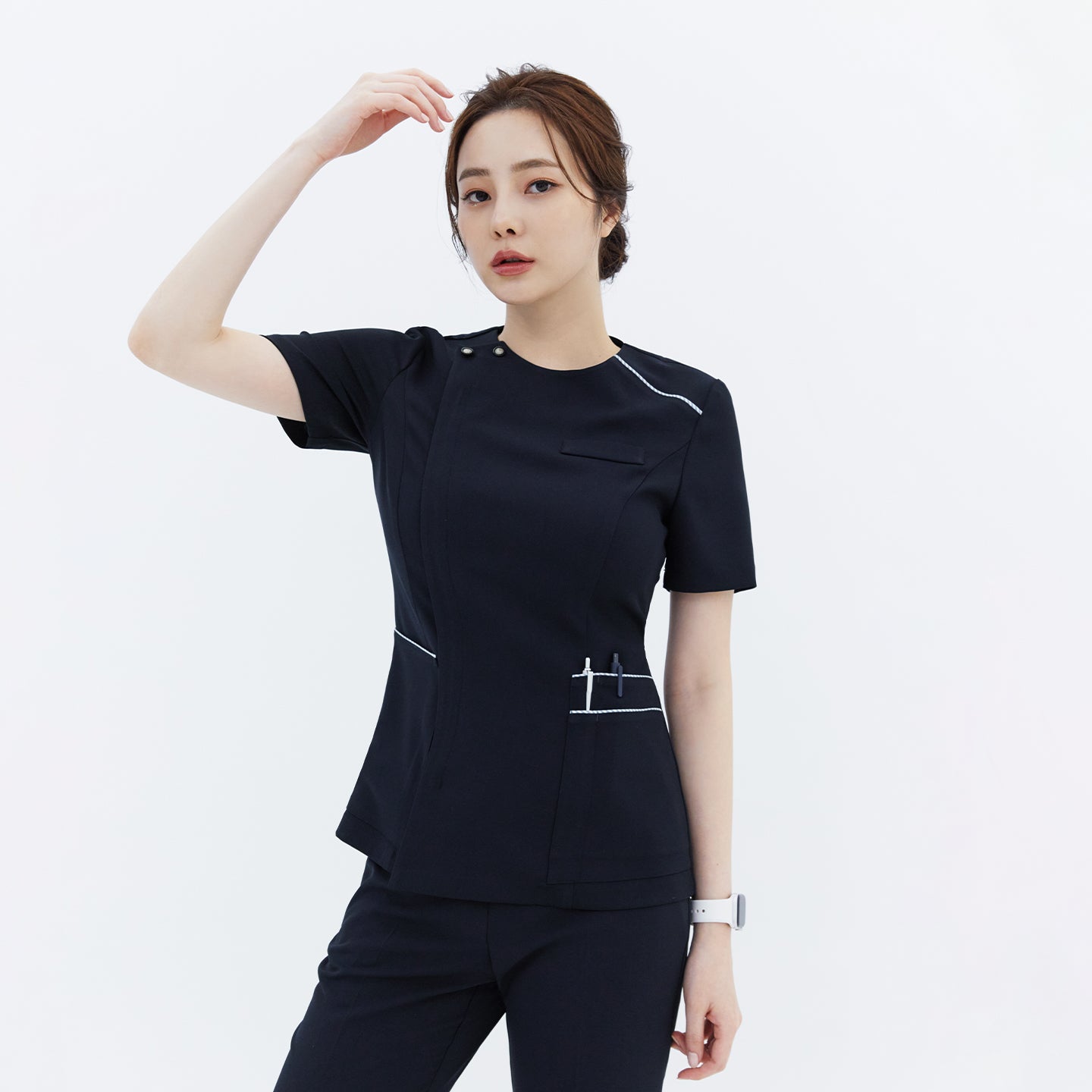 A woman wearing a navy round-neck front zipper top with white accents and button details on the shoulder,Navy