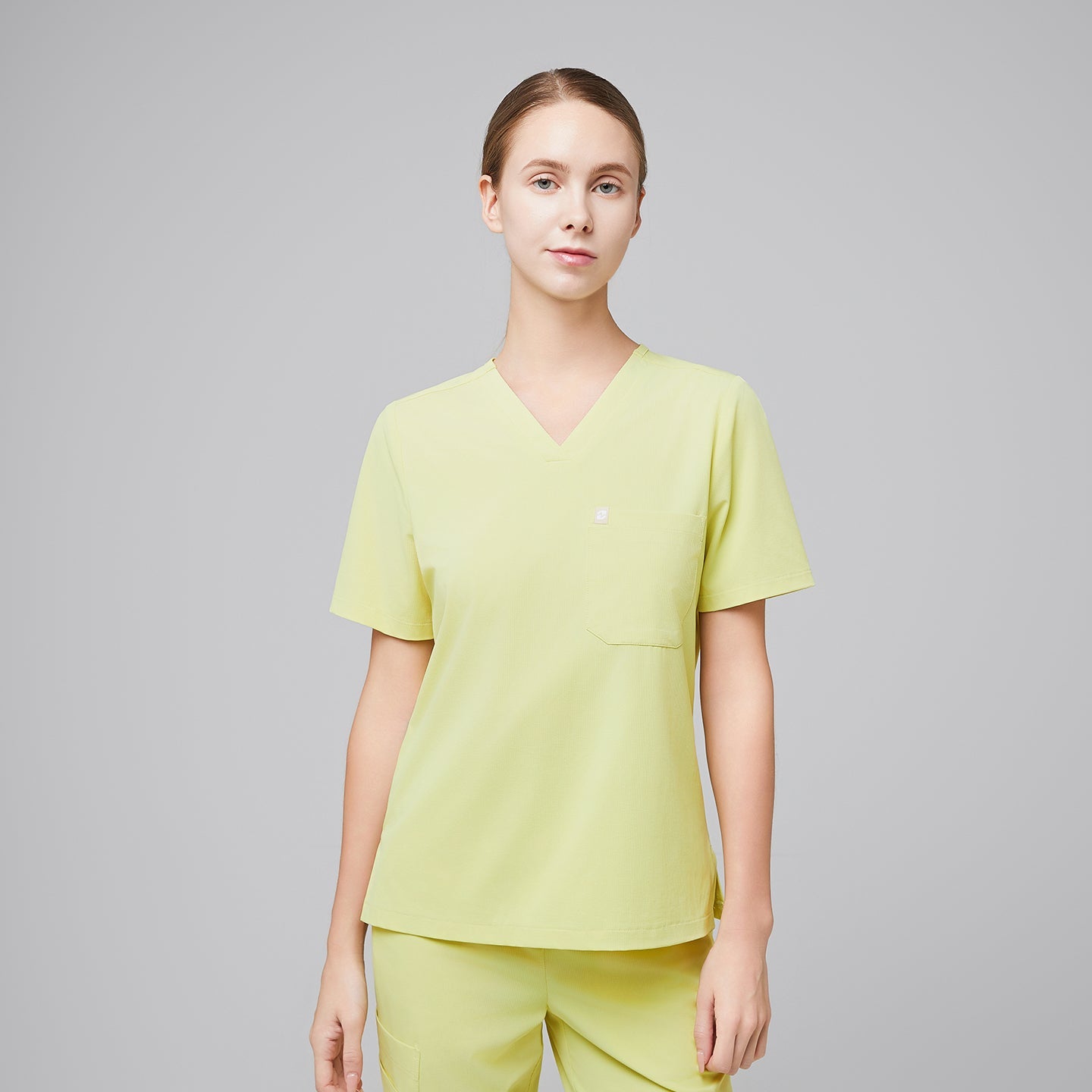 Female healthcare professional wearing a pineapple yellow scrub top and pants, standing with a confident posture,Pineapple Yellow