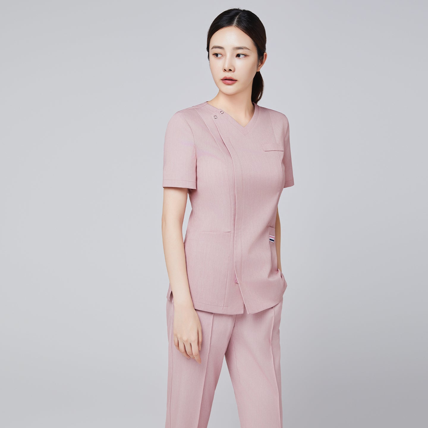 Soft pink short-sleeve scrub set with V-neck top and side pocket details, styled for a modern medical professional look,Soft Pink