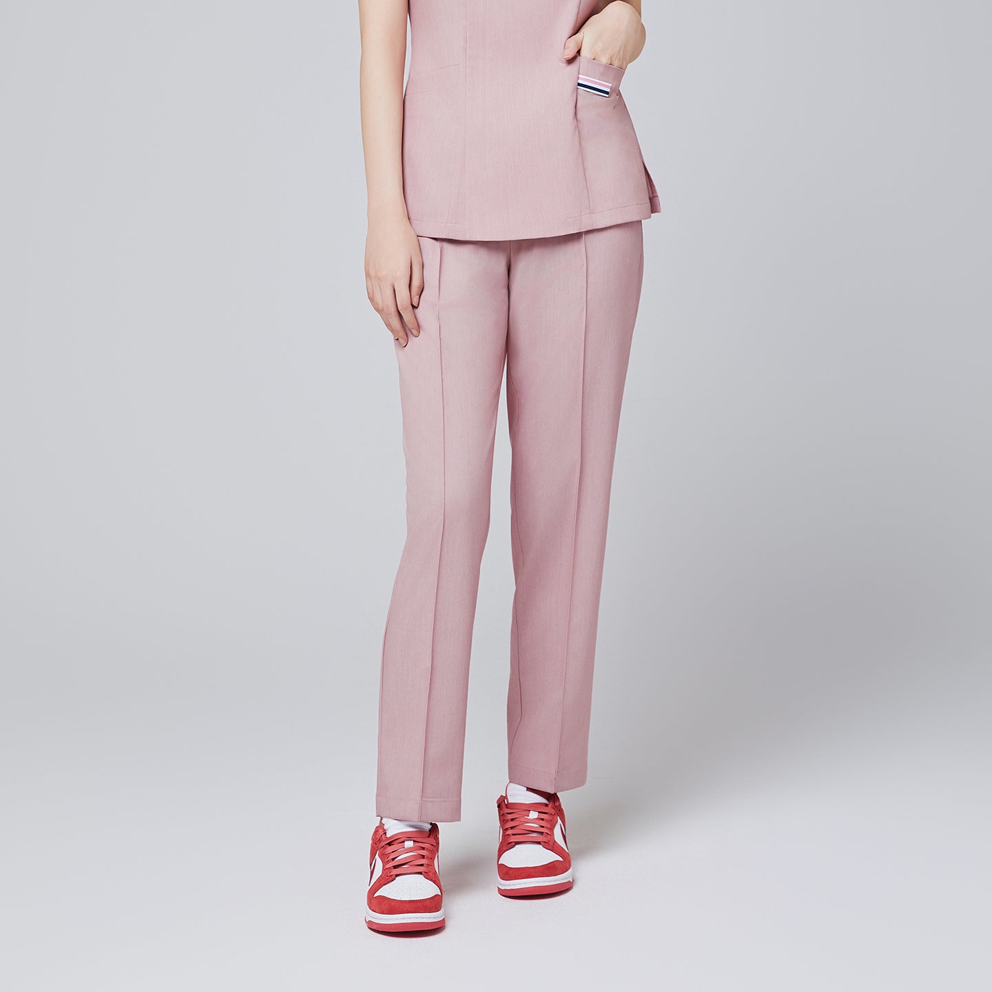 Soft pink banding scrub pants with a relaxed fit, paired with red sneakers, perfect for professional medical wear,Soft Pink