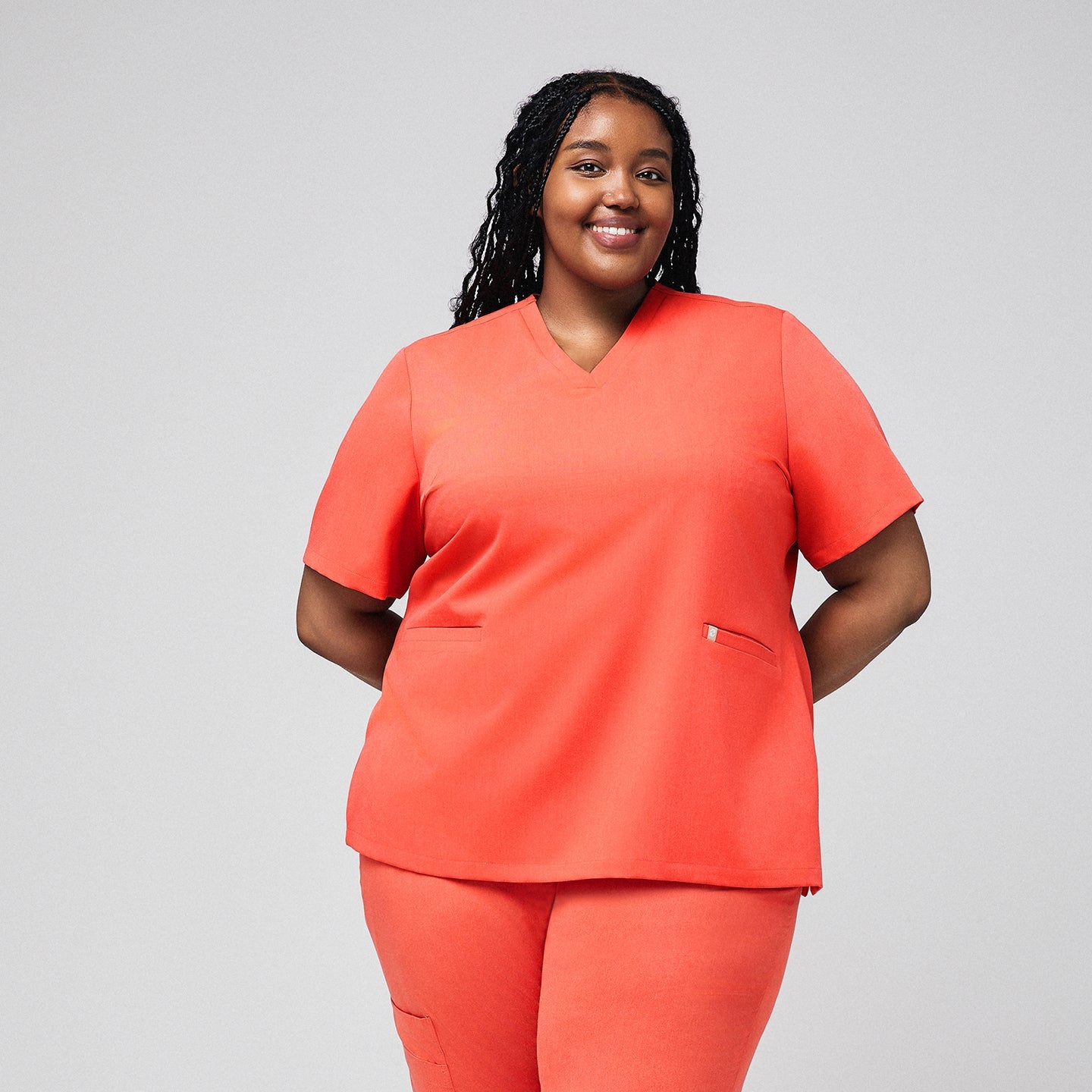 Plus-size healthcare professional wearing Tiger orange scrub set with double pockets,Tiger Orange