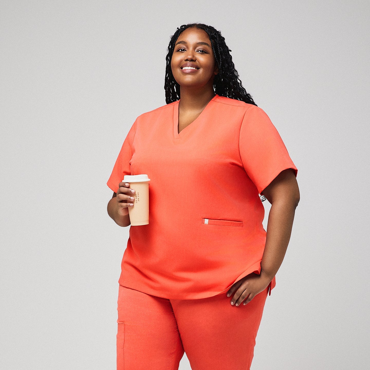 Plus-size healthcare professional in Tiger orange scrub set holding a coffee tumbler,Tiger Orange