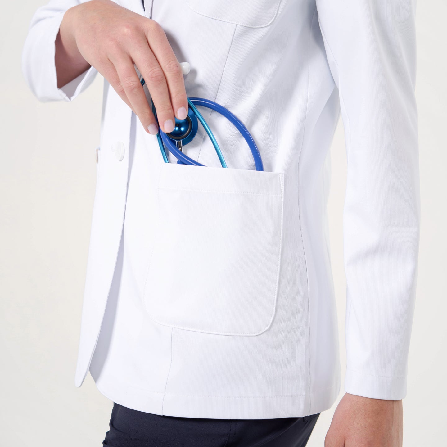 White lab coat LCW-02 pocket detail, close-up showing large patch pocket and smooth textured fabric.