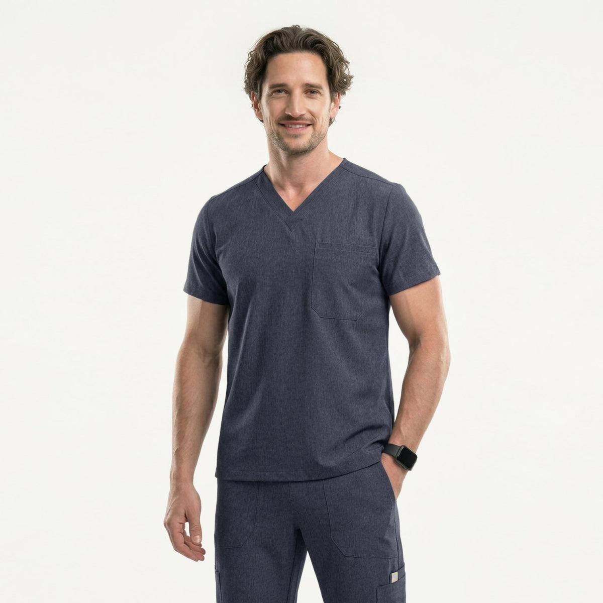Male healthcare professional wearing a charcoal gray V-neck scrub top with three pockets and black stethoscope around neck, standing against a plain background,Charcoal Gray