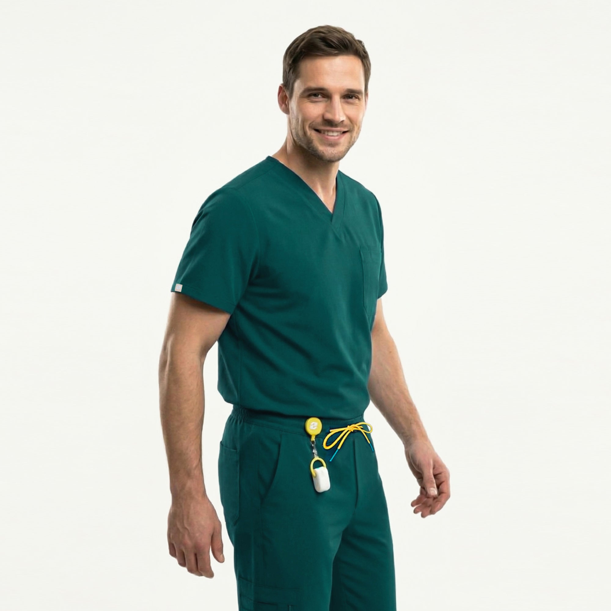 A male model wears the Zenir Pine-Green 3-Pocket Scrub Top with matching pants, showing a clean V-neck design, a functional chest pocket, and a comfortable fit that allows easy movement.