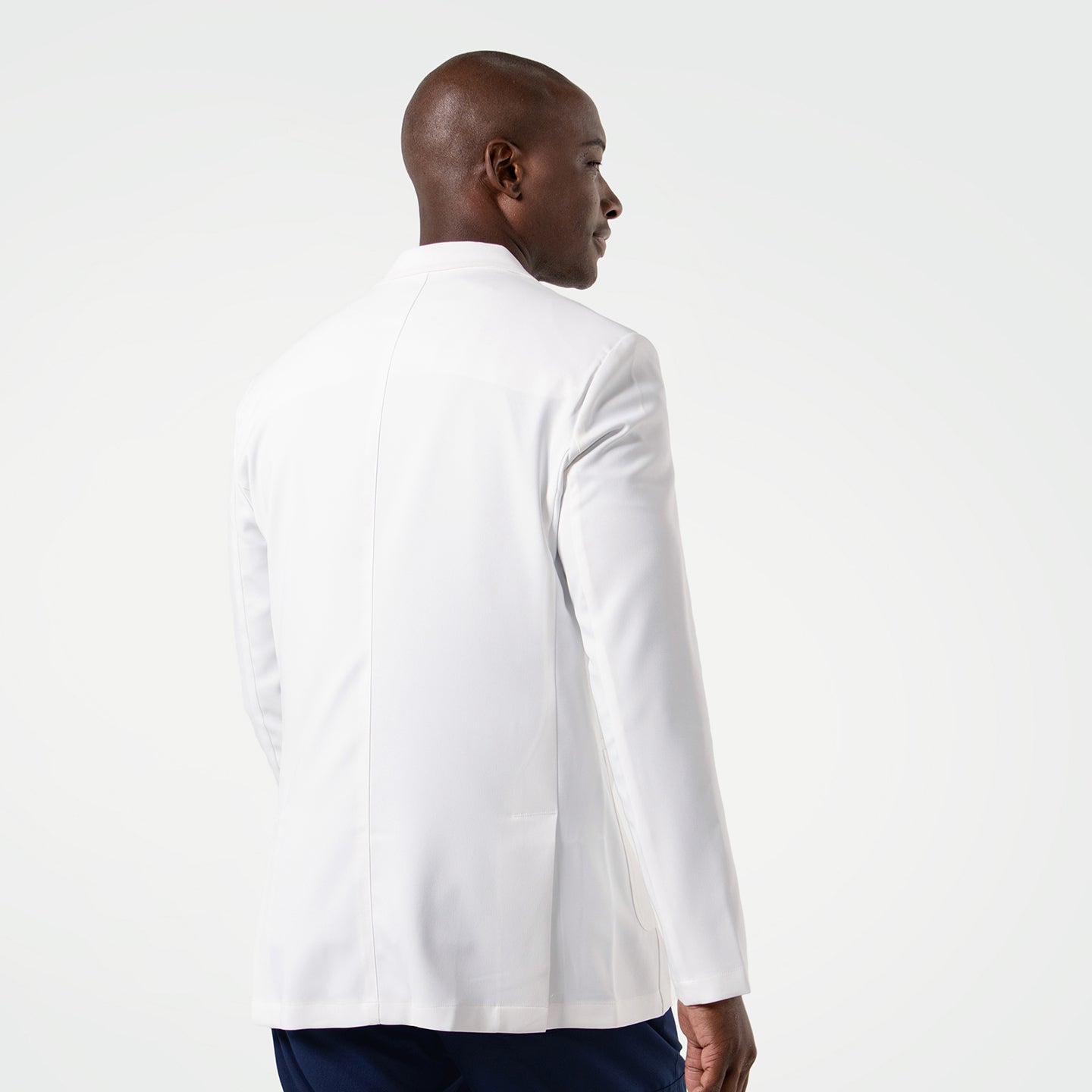 The model is shown from the back, highlighting the clean lines and tailored fit of the men’s LCM-100 lab coat.