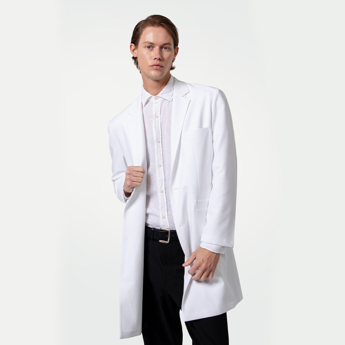 Male doctor wearing a white lab coat over a white dress shirt and black trousers, standing with one hand