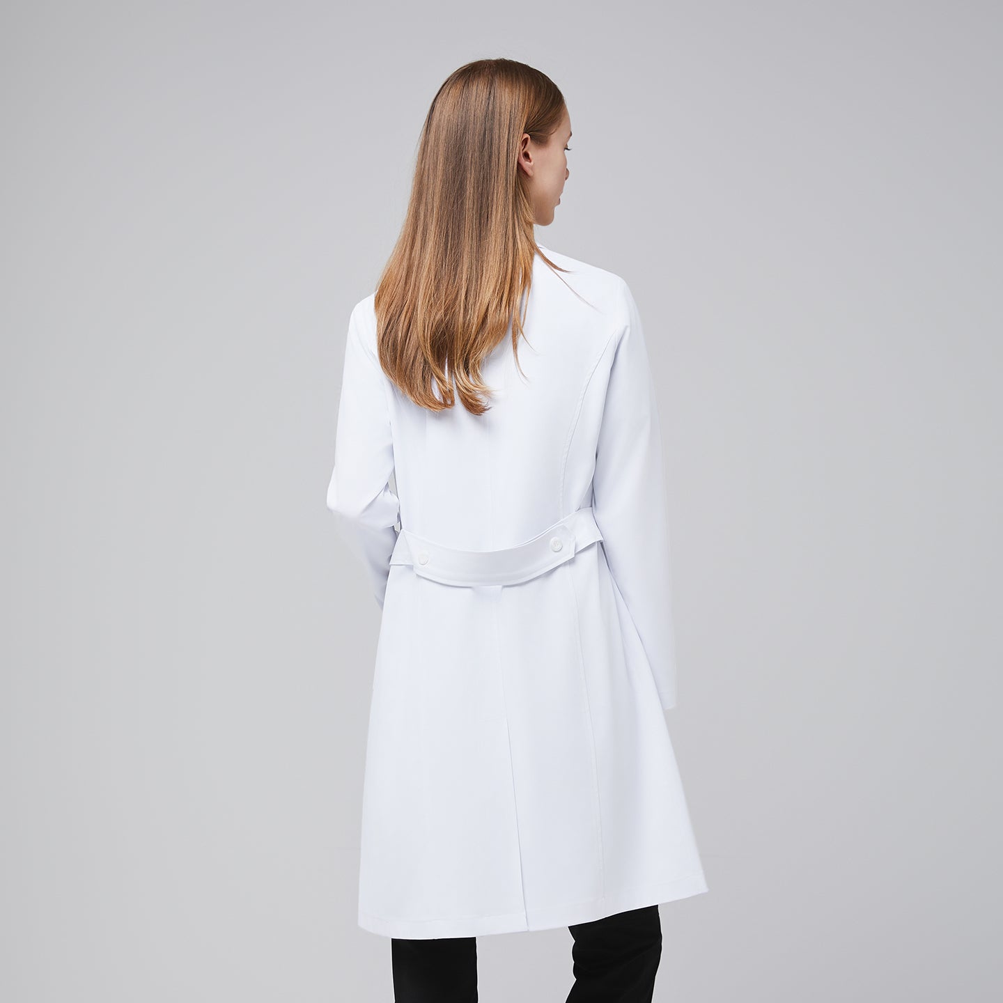 Model facing back, with a white long lab coat and black scrub top, black scrub pants, and black sneakers,White
