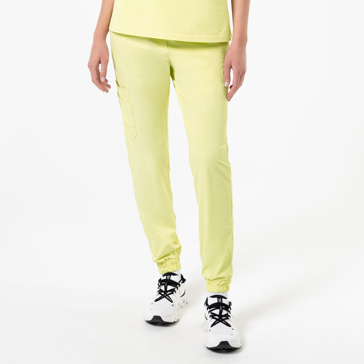 Front view of a person wearing StretchFit Jogger Scrub Pants in Pineapple Yellow, standing with arms relaxed at the sides.