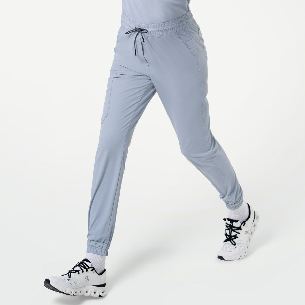 Close-up of a person walking in StretchFit Jogger Scrub Pants in Cool Gray, showing the side pockets and drawstring waistband.