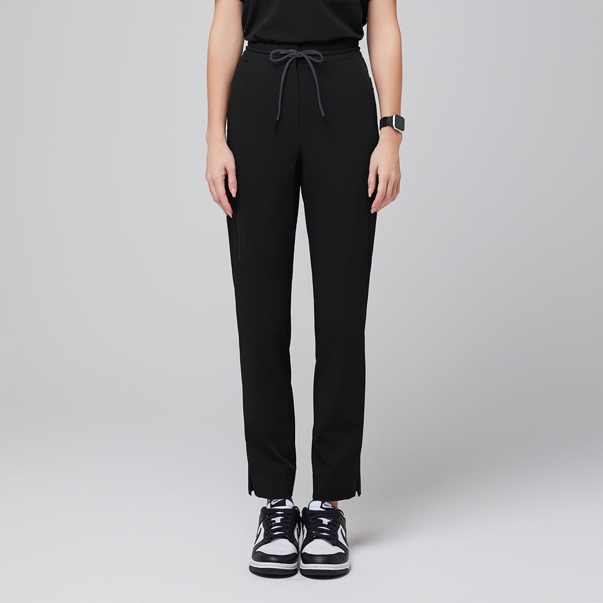 Streamlined scrub pants featuring a drawstring waist, zipper pocket, and split hem, paired with casual sneakers for a professional yet relaxed look,Eco Black