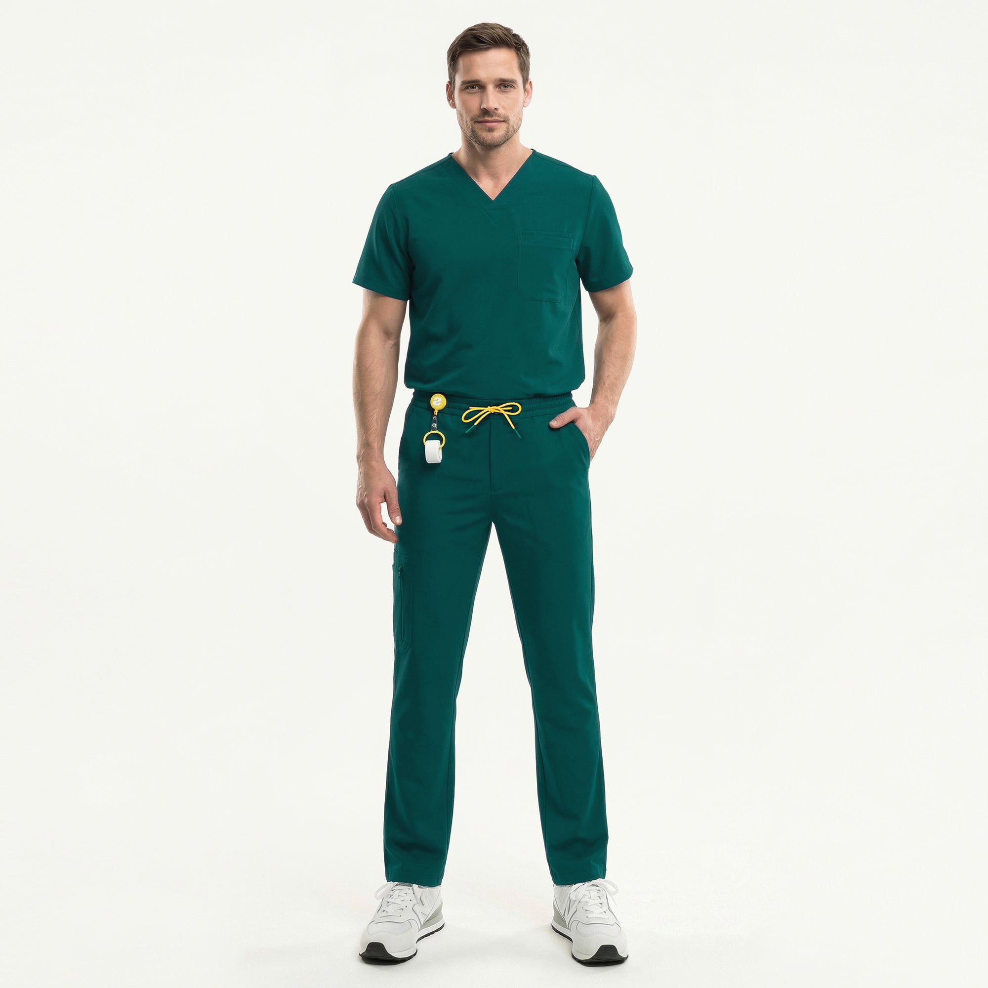 A male model is shown wearing Pine-Green 3-Pocket Scrub Top, styled with matching Pine-Green scrub pants for a clean and coordinated medical uniform look. The scrub top features a classic V-neckline and a practical chest pocket, offering both functionality and a streamlined appearance suitable for clinical environments. The model is captured mid-step, highlighting the comfortable fit and easy mobility of the fabric, making it ideal for long, active shifts in healthcare settings.