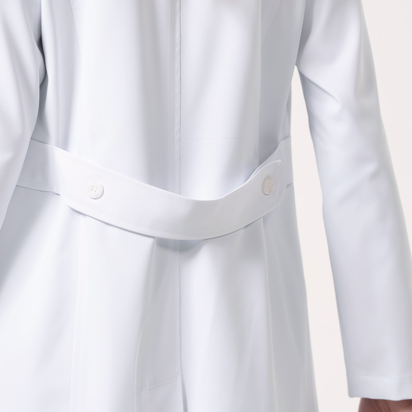 Close-up of the back of the Women’s Long Lab Coat LCW-04 in white, highlighting the buttoned belt detail at the waist.