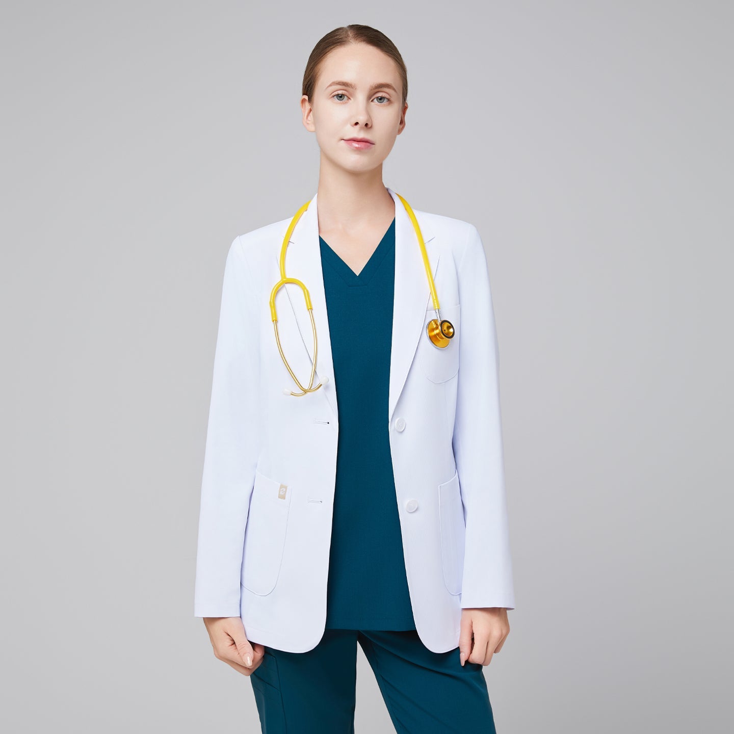 Polished in white, lab coat Zenir with notched lapels and two-button front, model wearing with stethoscope.
